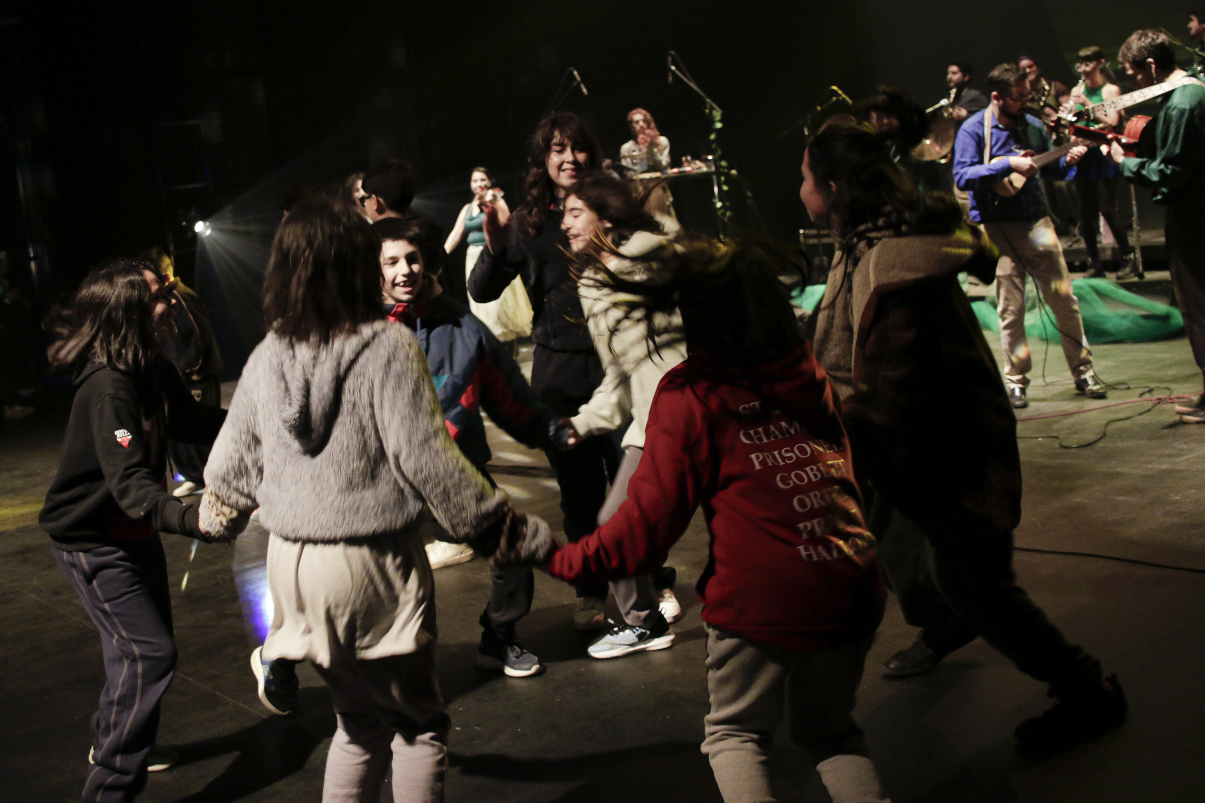 Participantes bailando en el escenario durante un concierto educativo de Chile Puerto Folk.