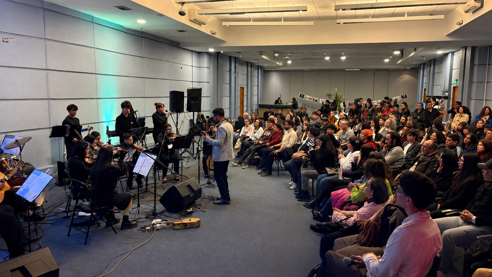 Presentación musical de ECAV ante una comunidad reunida en una sala.